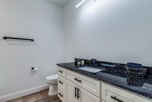 bathroom with vanity, toilet, and hardwood / wood-style floors