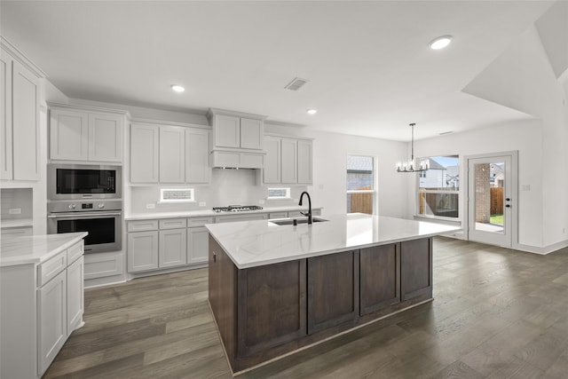 kitchen with a notable chandelier, dark wood-type flooring, white cabinets, and oven