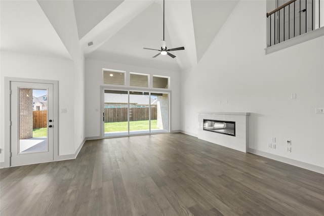 unfurnished living room with ceiling fan, high vaulted ceiling, and dark hardwood / wood-style floors