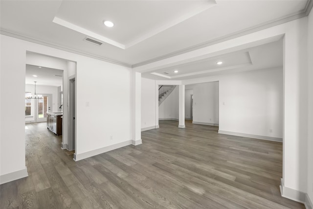 unfurnished room featuring hardwood / wood-style flooring, a chandelier, and a tray ceiling