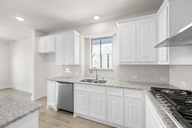 kitchen with white cabinetry, sink, tasteful backsplash, light hardwood / wood-style floors, and appliances with stainless steel finishes