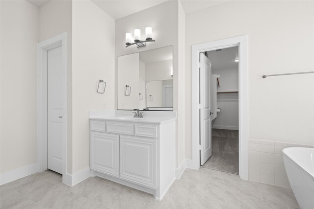 bathroom featuring tile patterned flooring, vanity, and a bathing tub