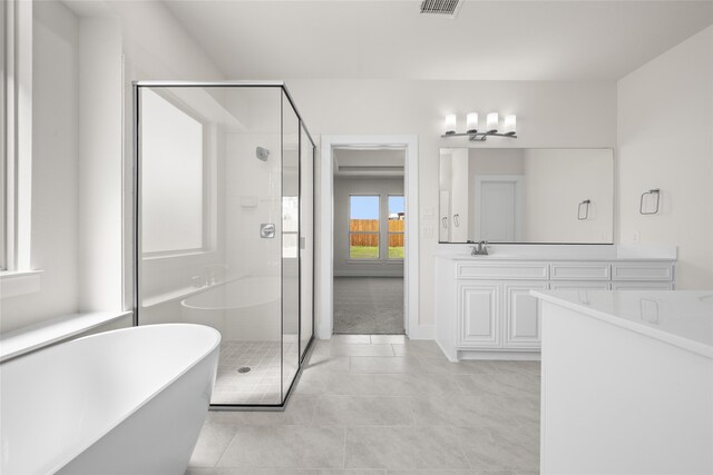 bathroom featuring tile patterned flooring, vanity, and shower with separate bathtub