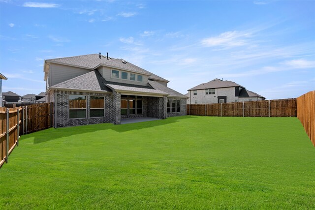 back of property featuring a yard and a patio