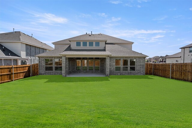 back of property with a patio area and a lawn