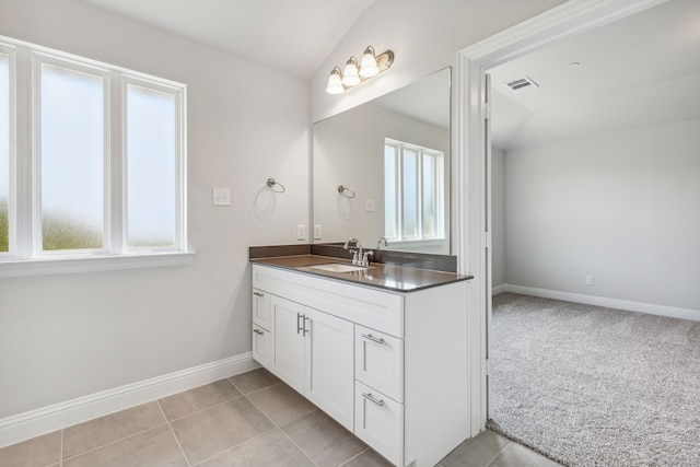 bathroom featuring tile patterned flooring, vanity, and lofted ceiling