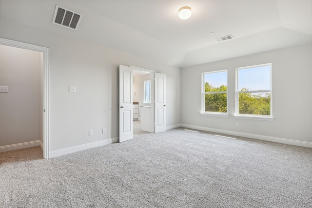 unfurnished bedroom with lofted ceiling and light carpet