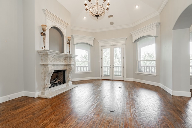 unfurnished living room with a premium fireplace, a notable chandelier, french doors, and dark hardwood / wood-style floors