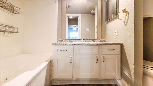 bathroom with vanity, a textured ceiling, and a washtub