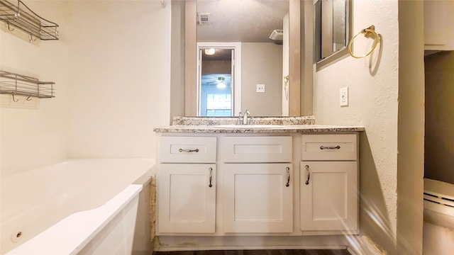 bathroom with vanity, a bath, and a textured ceiling