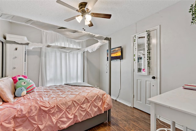 bedroom with ceiling fan, dark hardwood / wood-style flooring, and a textured ceiling