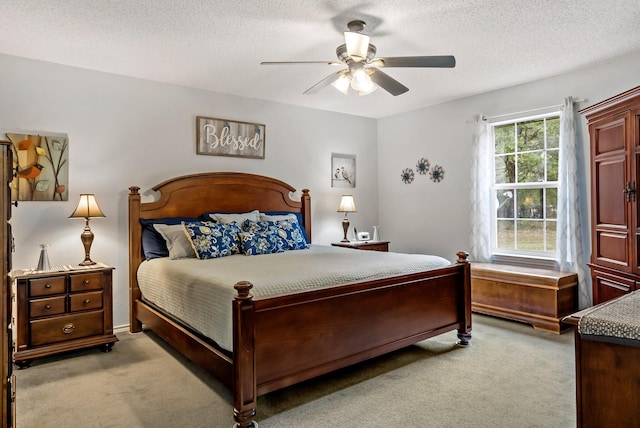 carpeted bedroom featuring a textured ceiling and ceiling fan