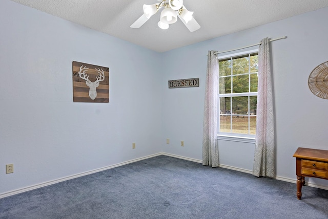 carpeted spare room with a wealth of natural light, a textured ceiling, and ceiling fan