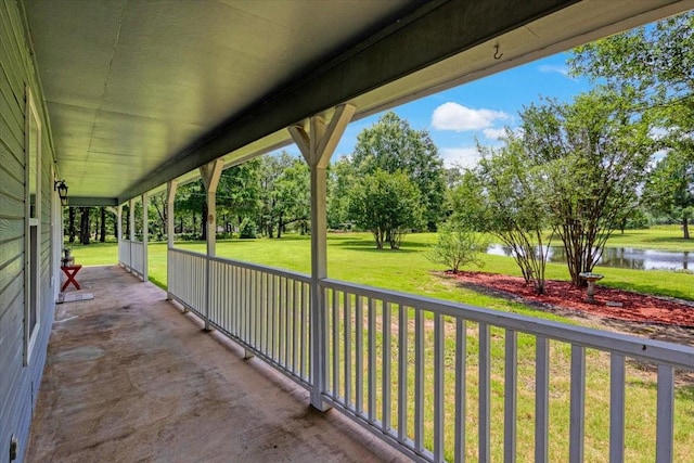 view of patio / terrace featuring a water view and covered porch