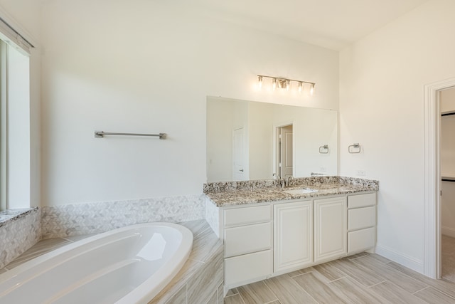 bathroom with vanity and tiled bath