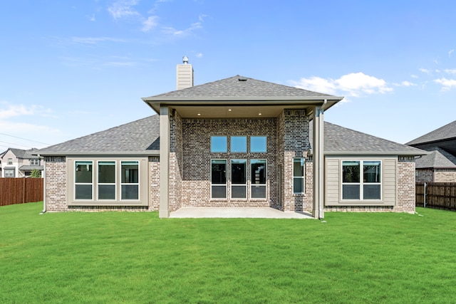 back of house featuring a patio area and a lawn