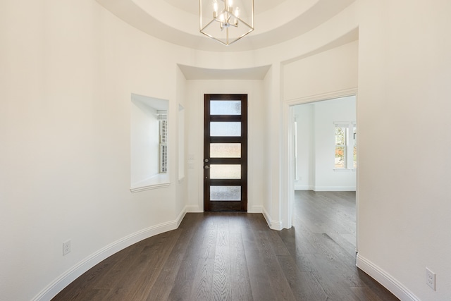 entrance foyer with an inviting chandelier and dark hardwood / wood-style flooring