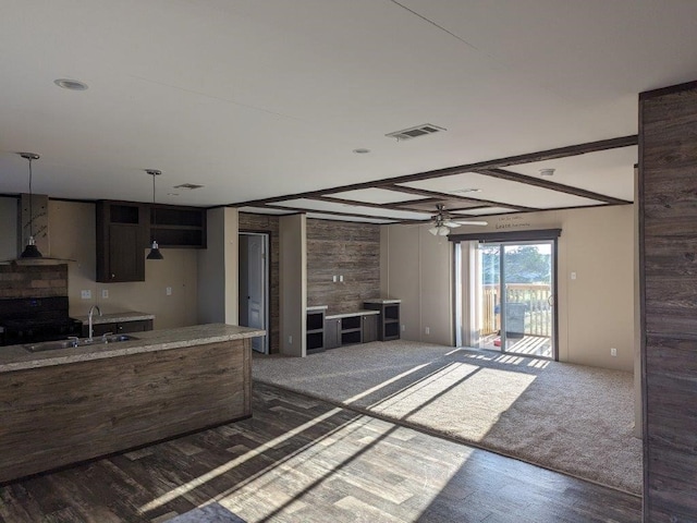 kitchen with visible vents, wall chimney exhaust hood, carpet flooring, and a sink