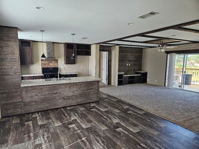 kitchen featuring black stove, beamed ceiling, range hood, sink, and dark brown cabinetry