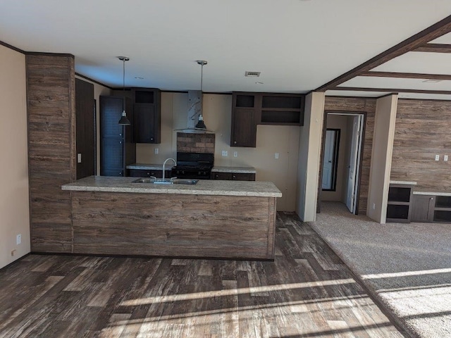 kitchen featuring black range oven, dark hardwood / wood-style floors, exhaust hood, kitchen peninsula, and sink