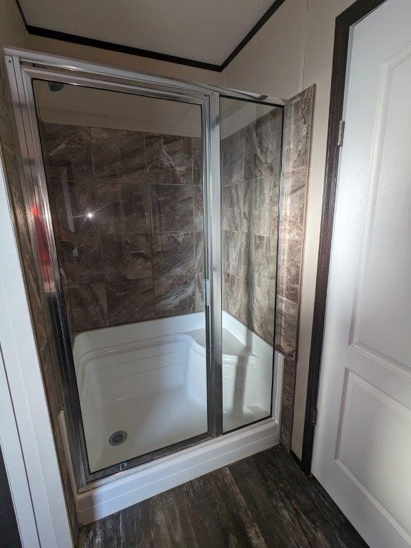 full bathroom with wood finished floors and a shower stall