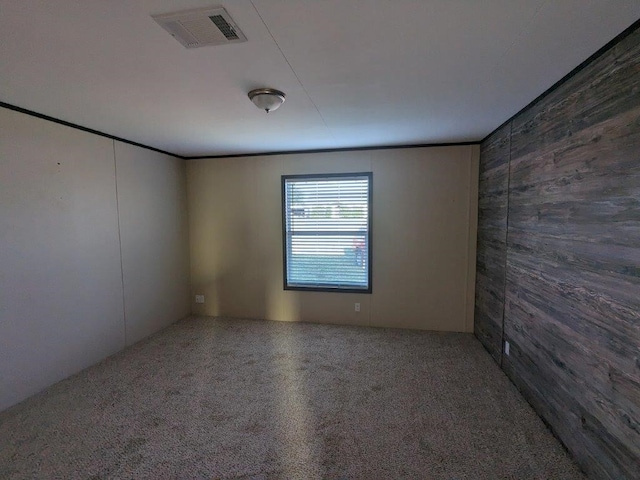 unfurnished room featuring visible vents and wood walls
