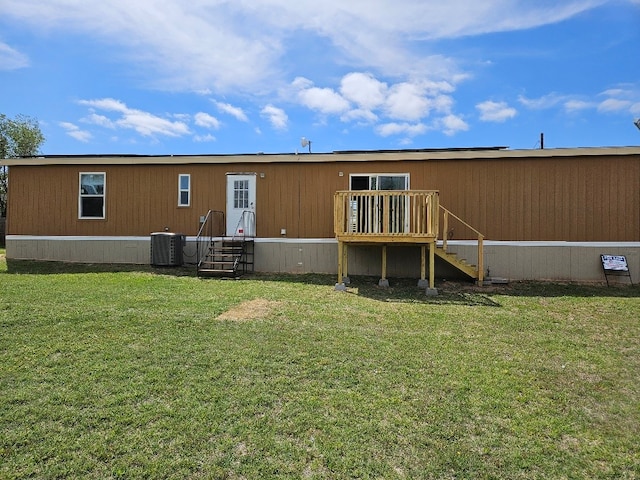 rear view of house with a yard and cooling unit