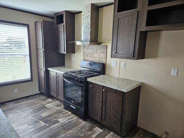 kitchen featuring black gas stove, dark wood-style flooring, wall chimney range hood, and light countertops
