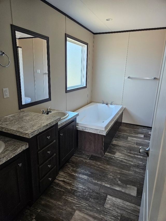 full bath with wood finished floors, vanity, and a bath