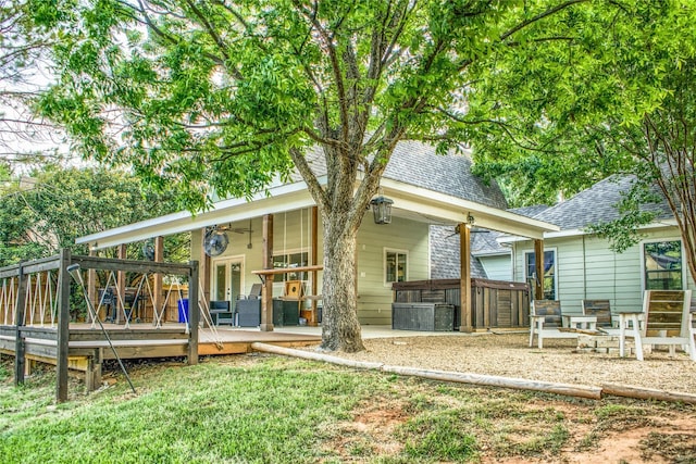 back of house with central air condition unit, a deck, and a hot tub