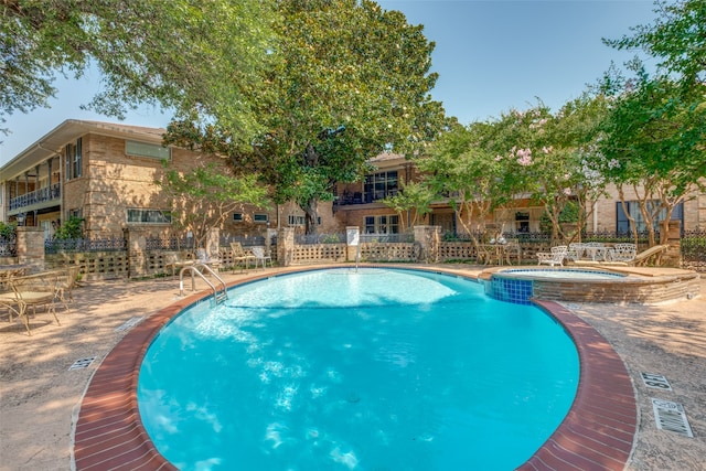 view of pool featuring a community hot tub and a patio area