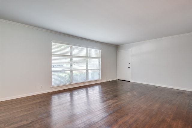 empty room featuring crown molding and dark wood-type flooring