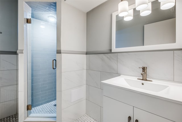 bathroom featuring decorative backsplash, vanity, tile walls, and a shower with shower door