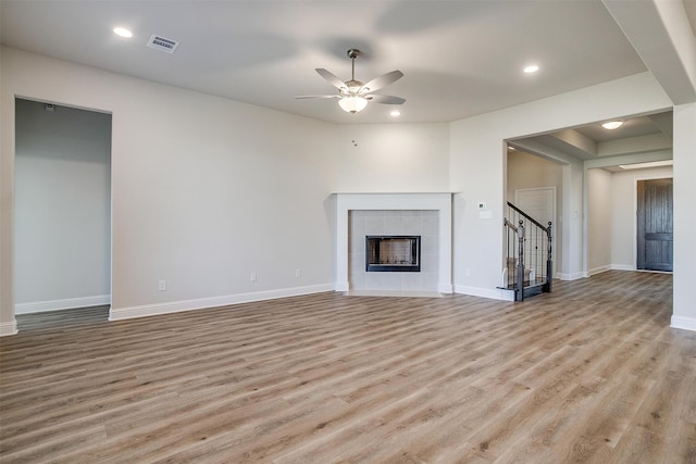 unfurnished living room featuring a fireplace, light wood-type flooring, and ceiling fan