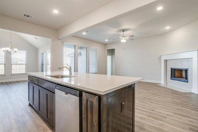 kitchen with sink, backsplash, light hardwood / wood-style floors, a center island with sink, and white cabinets