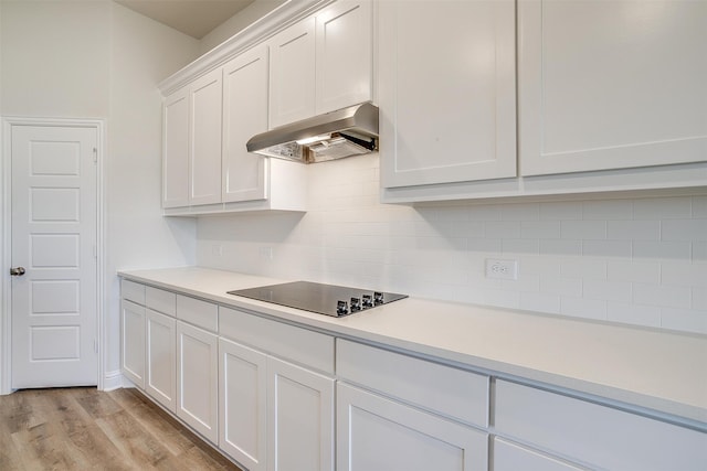 kitchen with light hardwood / wood-style flooring, white cabinetry, tasteful backsplash, and black electric cooktop