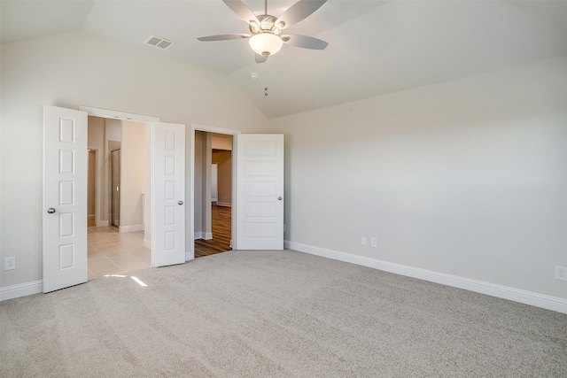 unfurnished bedroom with ceiling fan, light colored carpet, and vaulted ceiling