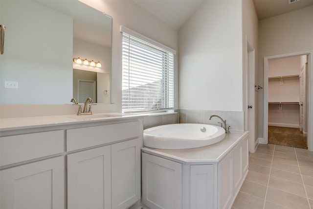 bathroom featuring tile patterned floors, vanity, and a washtub