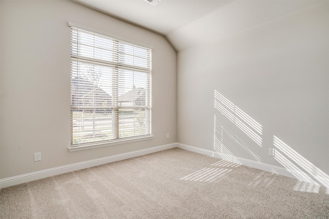 carpeted spare room with lofted ceiling