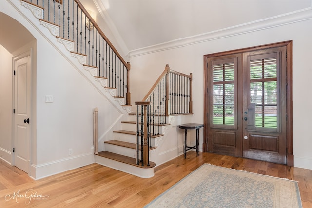 foyer entrance featuring wood-type flooring and crown molding