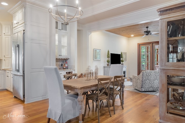 dining space featuring ornamental molding, ceiling fan with notable chandelier, and light wood-type flooring