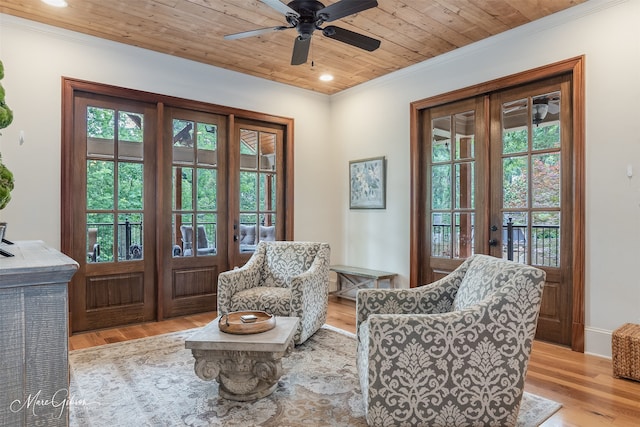 living area featuring light hardwood / wood-style floors, a wealth of natural light, and french doors