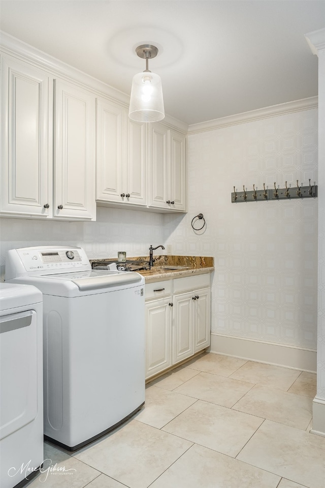 laundry area with washer and dryer, cabinets, ornamental molding, and sink