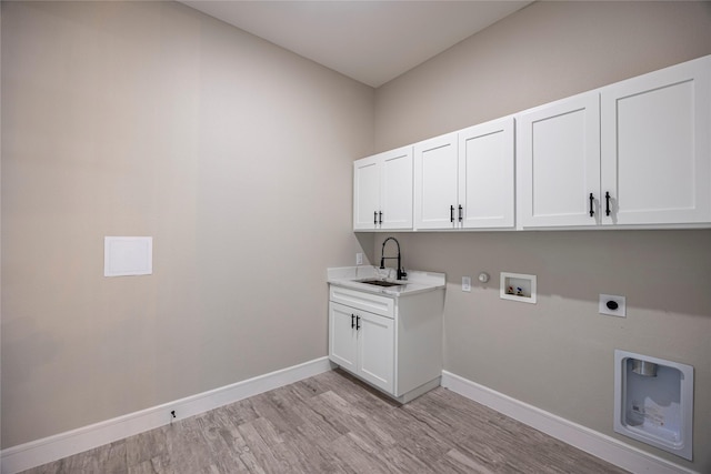 laundry room with sink, cabinets, electric dryer hookup, hookup for a gas dryer, and light wood-type flooring