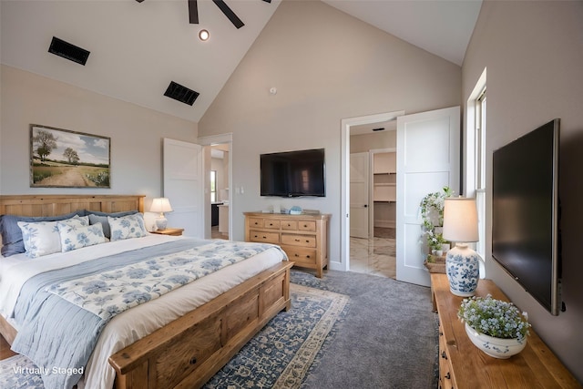 bedroom with carpet floors, ensuite bath, ceiling fan, and high vaulted ceiling