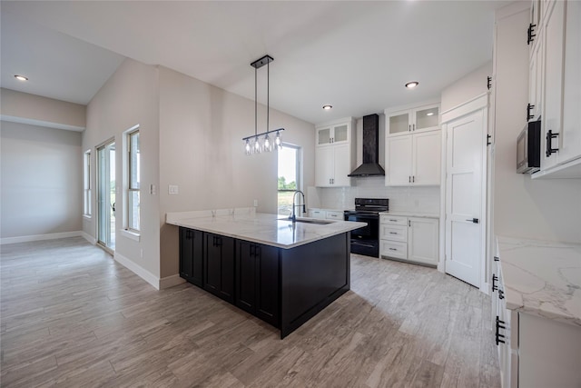 kitchen with white cabinets, sink, wall chimney exhaust hood, black / electric stove, and decorative light fixtures