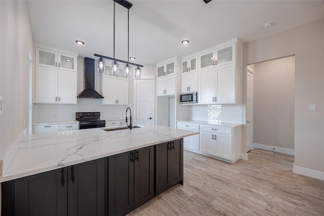 kitchen featuring white cabinets, wall chimney exhaust hood, black electric range oven, and sink