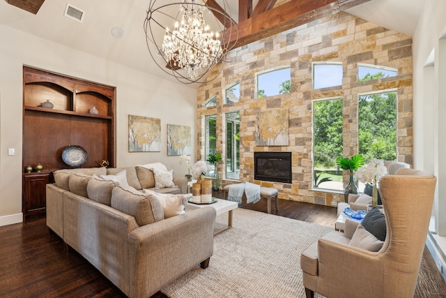 living room with dark wood-type flooring, an inviting chandelier, beamed ceiling, a towering ceiling, and a fireplace