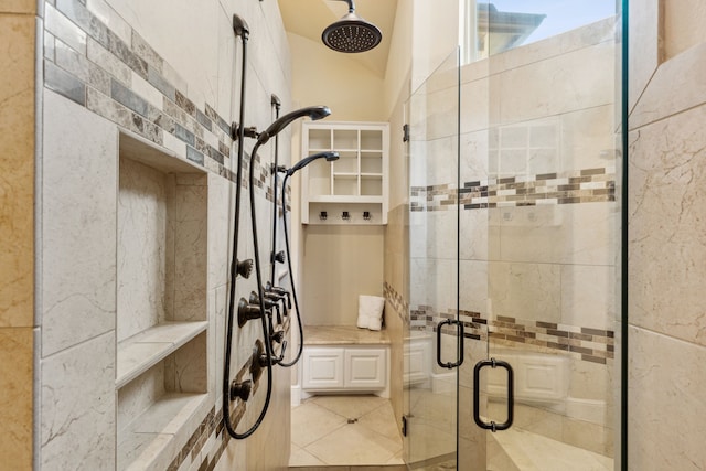 bathroom with a shower with door and tile patterned flooring