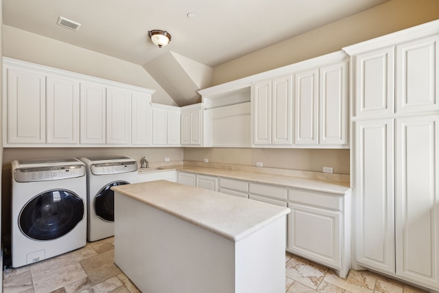 clothes washing area featuring sink, cabinets, and washing machine and clothes dryer